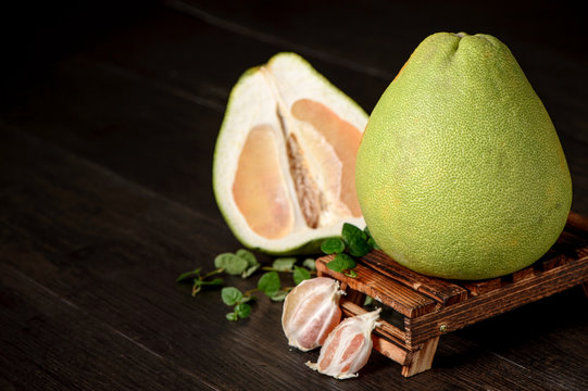 fresh grapefruit ,peeled grapefruit and grapefruit with slices on wooden table isolated on black background
