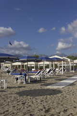 Sun umbrellas on Marina di Massa beach in Tuscany, overlooking the Apuan Alps