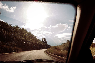 On the road from the passenger view. In the passenger seat. Heading to horizon. Sunny car ride. Enjoy the ride. Eyes on the road.