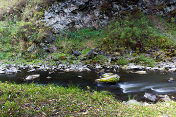 River in the forest with stones. Silk water.