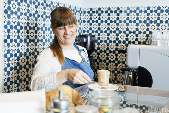 Female barista preparing latte