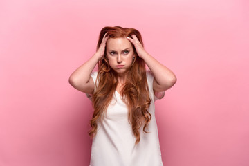 Naklejka premium The beautiful woman is offended on pink studio