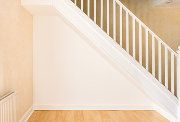 Newly decorated wall under staircase in a domestic room.
