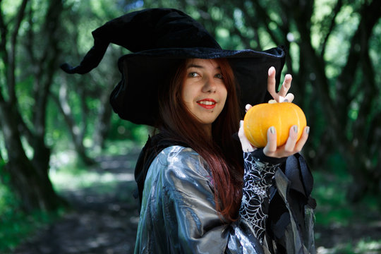 Portrait of young witch with pumpkin