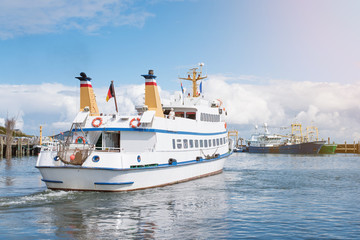 excursion boat leaving harbor on the island of Sylt, Germany under blue summer sky