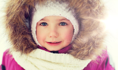 face of happy little kid or girl in winter clothes