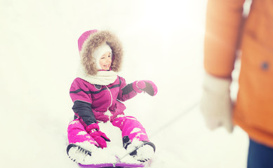 happy little kid on sled outdoors in winter
