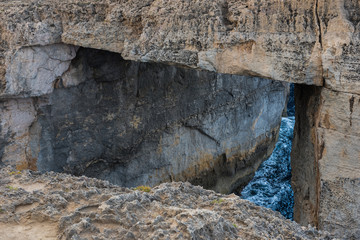 Naklejka premium Wied il Mielah canyon, natural arch over the sea. Gozo, Malta