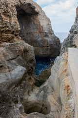 Wied il Mielah canyon, natural arch over the sea. Gozo, Malta