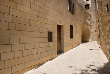 Narrow medieval street with stone houses in Mdina, Malta