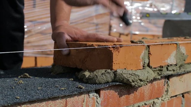 Work lays bricks on a construction site on open air