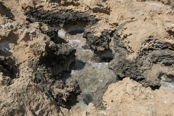 Crystallized salt in a rock hole after the sea water evaporated