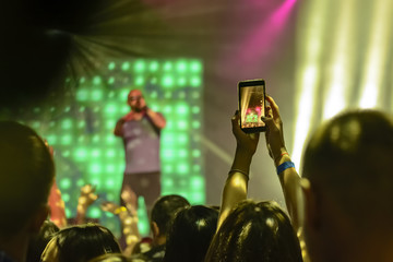 Fototapeta na wymiar silhouette of hands with a smartphone at a concert