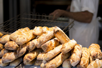 Homem retirando fornada de pãp francês fresco do forno em padaria no brasil foco seletivo