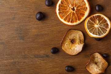 Slices of dried fruits on wooden board background