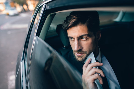 Young business man travelling by a car