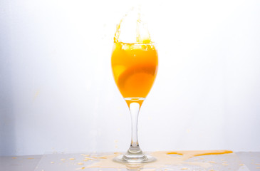 Orange juice splashing out of glass., Isolated white background.