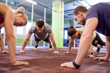 Fototapeta na wymiar group of people doing straight arm plank in gym