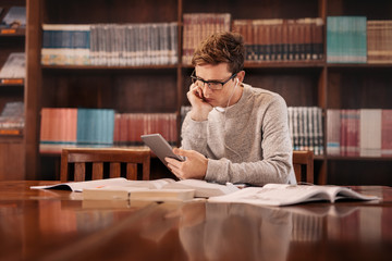 College student using tablet pc in library