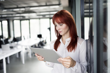 Businesswoman with tablet in her office working.