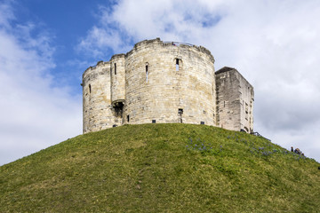 Fototapeta na wymiar wide angle shot of the York Castle - Cliffords Tower - against a deep blue sky and volumetric clouds, Yorkshire, England, UK