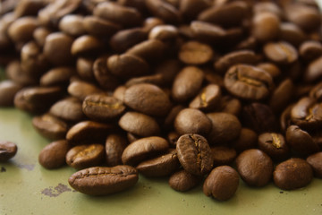 close up coffee beans on green metallic surface