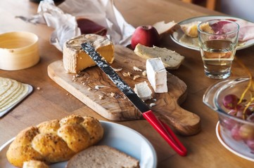 Wooden table with cheese, bread, ham and fruit