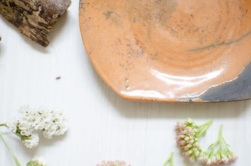 Ceramic set of dishes and cups. Decorative pottery on the wooden table with decorative dried flower