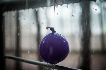 Droplets on the child balloon and metal handrail, summer rain