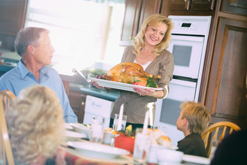 Thanksgiving: Mother Brings Roasted Turkey To Table