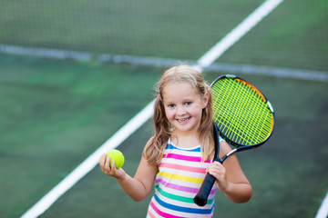 Child playing tennis on outdoor court