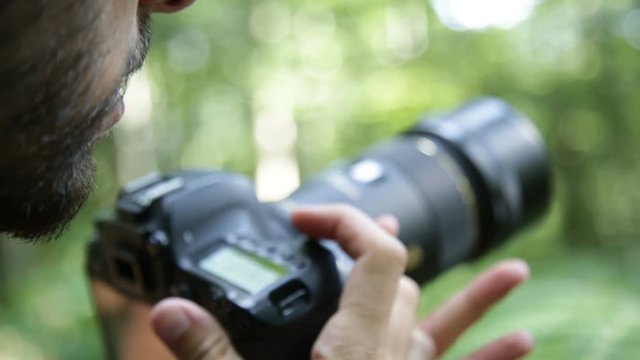 Fotografo sta fotografando delle piante con l'obbiettivo macro in montagna 
