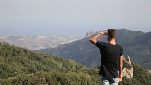 Esploratore con maglietta nera sta osservando il panorama