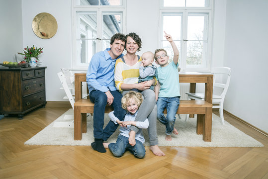 Family with three children in living room