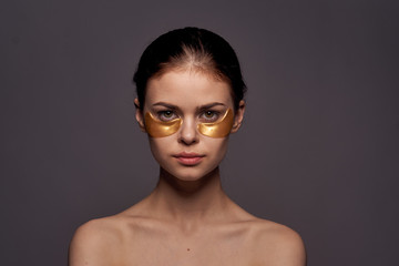 young woman in gold patches for the eyes