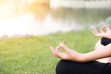Close up hands with lotus shape - woman do yoga in the park.