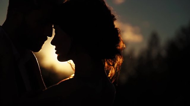 Young lovely couple hugging silhouette slowmotion