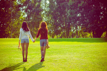 Portrait two young beautiful women enjoy life on a nature. Women's friendship as it is. Sisters rest in the park. The concept of friendship and relations among women