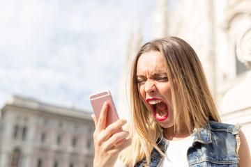 Angry and upset teenager screaming at the mobile telephone