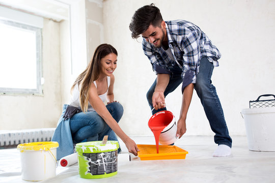 Lovely smiling couple painting new home,new house renovation