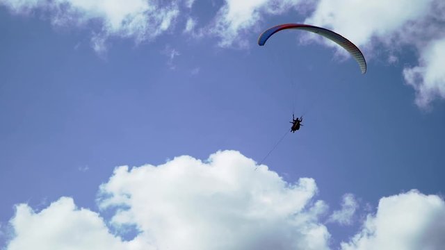Paraglider flying in the sky at sunny day