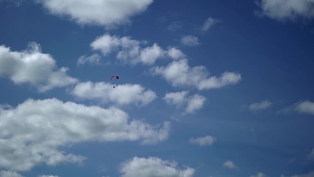 Paraglider flying in the sky at sunny day