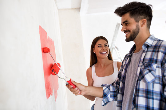 Lovely smiling happy couple painting new home