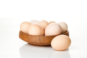 chicken eggs in a wooden plate isolated on white background