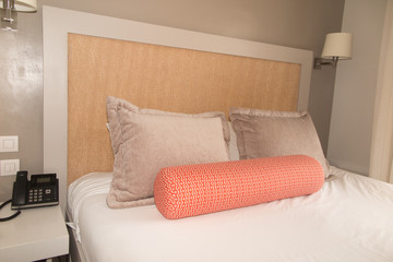 Modern decorative bedroom included king size bed with white sheets over it. There is a gray color wrap or rob lay on the bed
