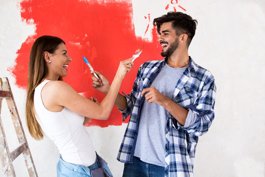 Smiling funny couple doing painting