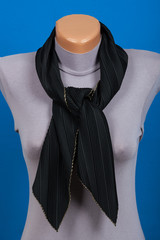 Black scarf on mannequin isolated on blue background.