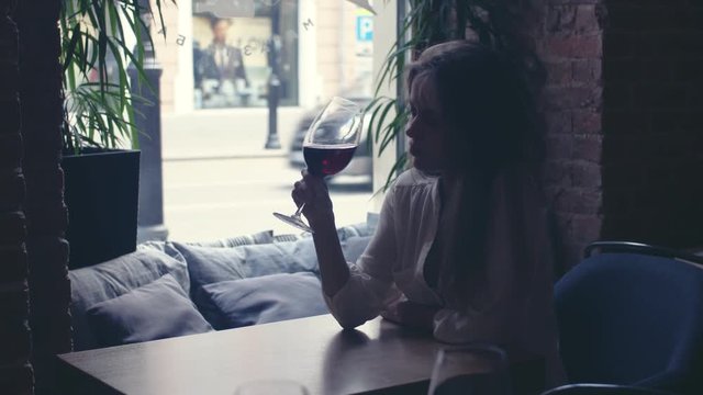 Young girl drinking wine in a restaurant