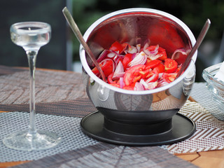 Fresh tomato and onion salad in bowl on table.