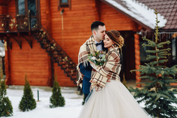 Winter wedding outdoors on background of snow-covered house.